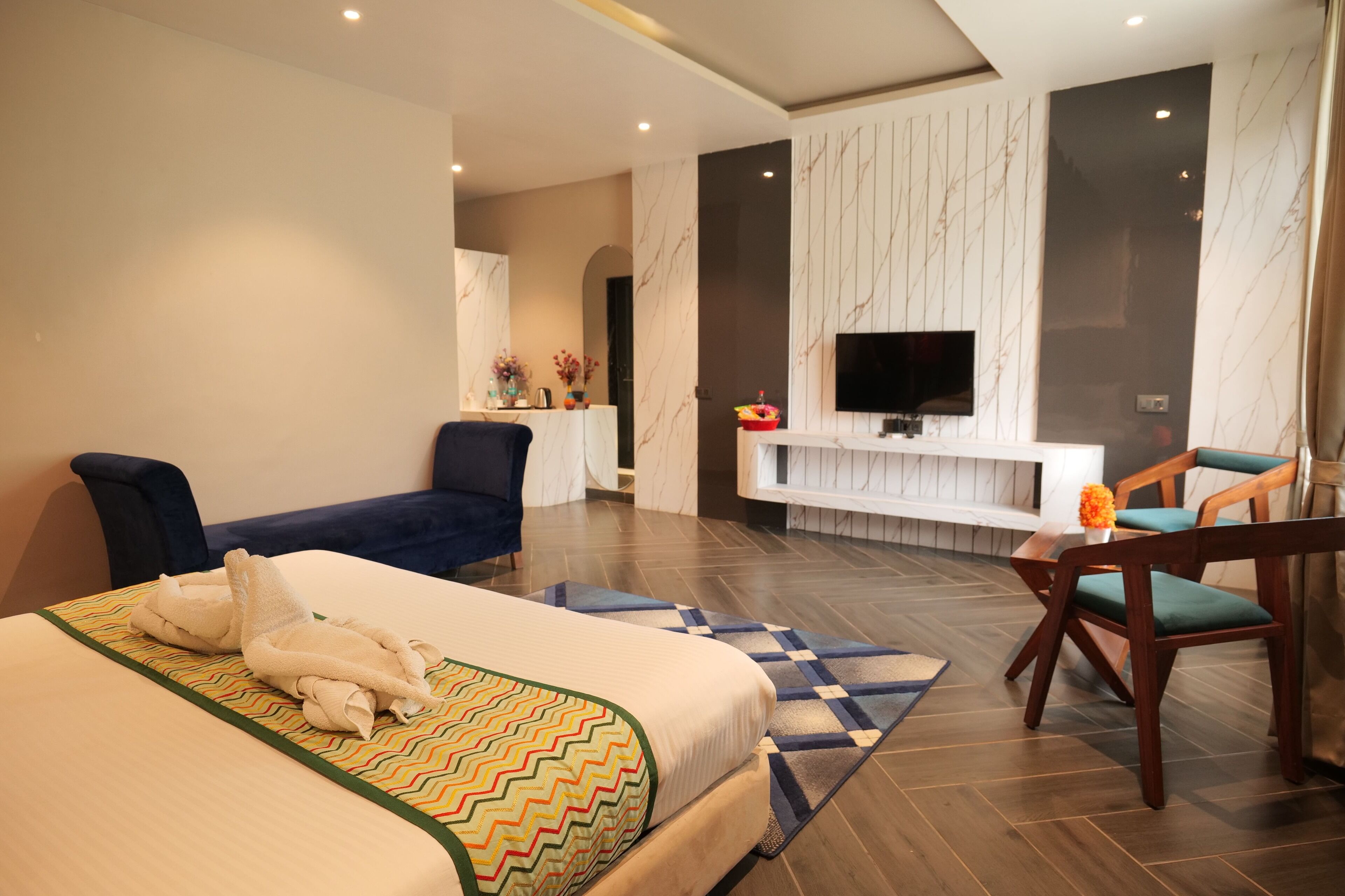 Een moderne hotelkamer met een groot bed, een bureau, een televisie en een zithoek.