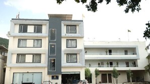 A multi-story building with a central entrance, balconies on the upper floors, and a flag on top. - Hotel 777, Pushkar (Pushkar)