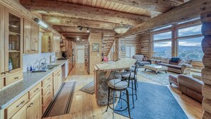 Ein Blockhaus-Innenraum mit Küche, Essbereich und Wohnzimmer.