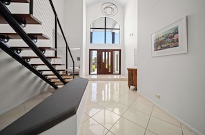 A modern interior with a staircase, a large window, and a framed picture on the wall.