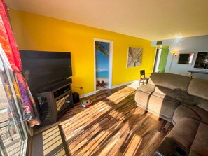 A living room with a fireplace, a sofa, and a colorful curtain.