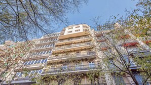 Um edifício de vários andares com varandas e uma combinação de estilos arquitetônicos.