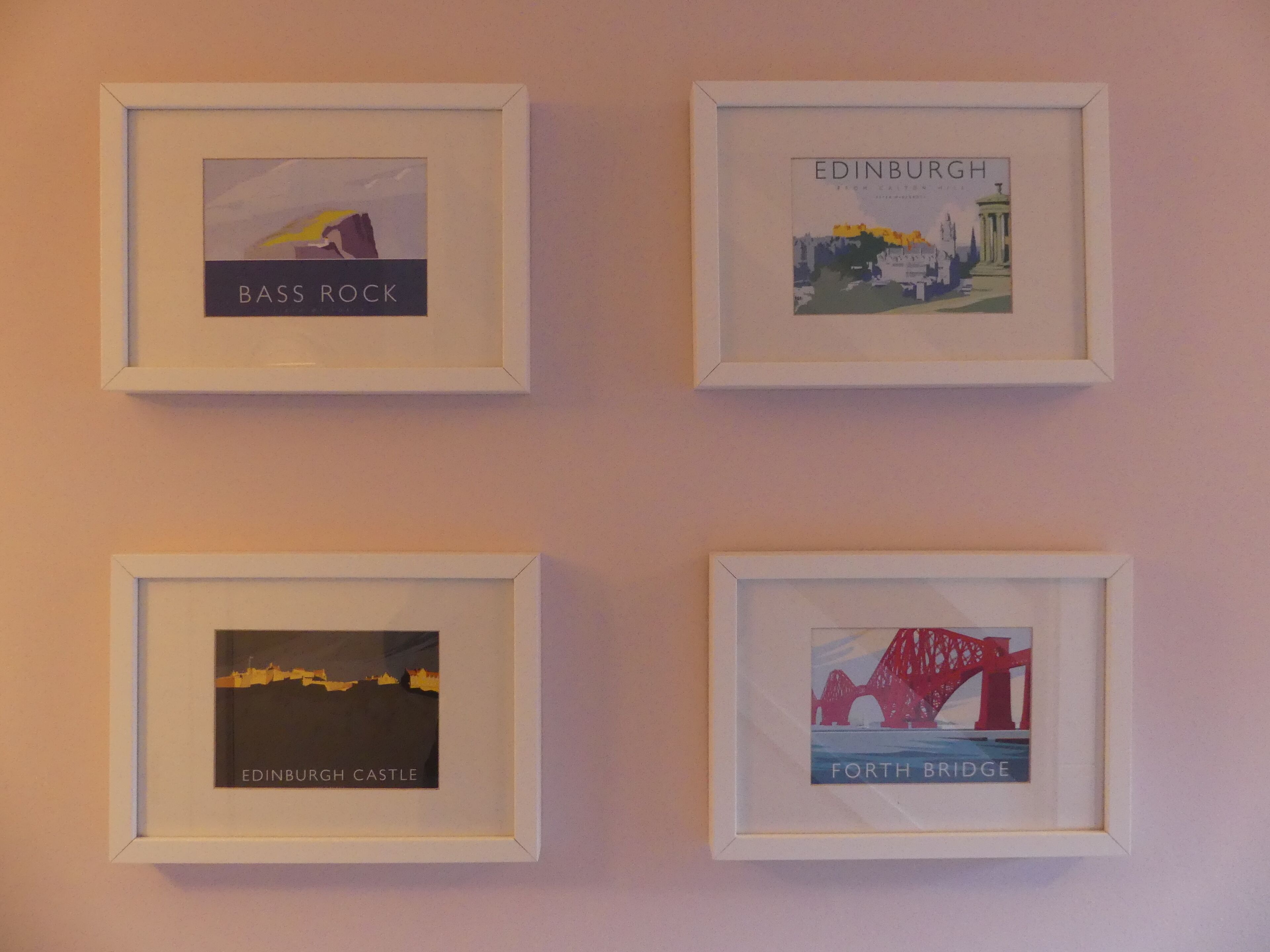 Quatre tableaux encadrés accrochés au mur.
