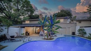 A backyard with a swimming pool, lounge chairs, and a covered patio area. - Modern 5BR w/ Pool, Cinema & Game Room (Dallas)
