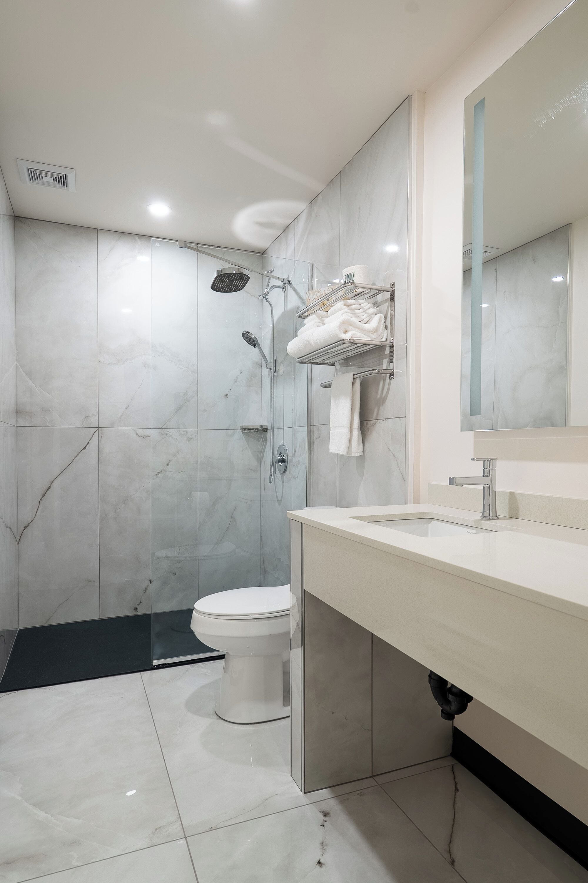 Un baño moderno con ducha, inodoro y lavamanos.
