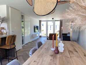 Enjoy meals in this dining area with a long table for two, a mounted TV, and a cozy seating area.