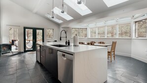Eine moderne Küche mit Kochinsel, Geschirrspüler und Essbereich mit Tisch und Stühlen.