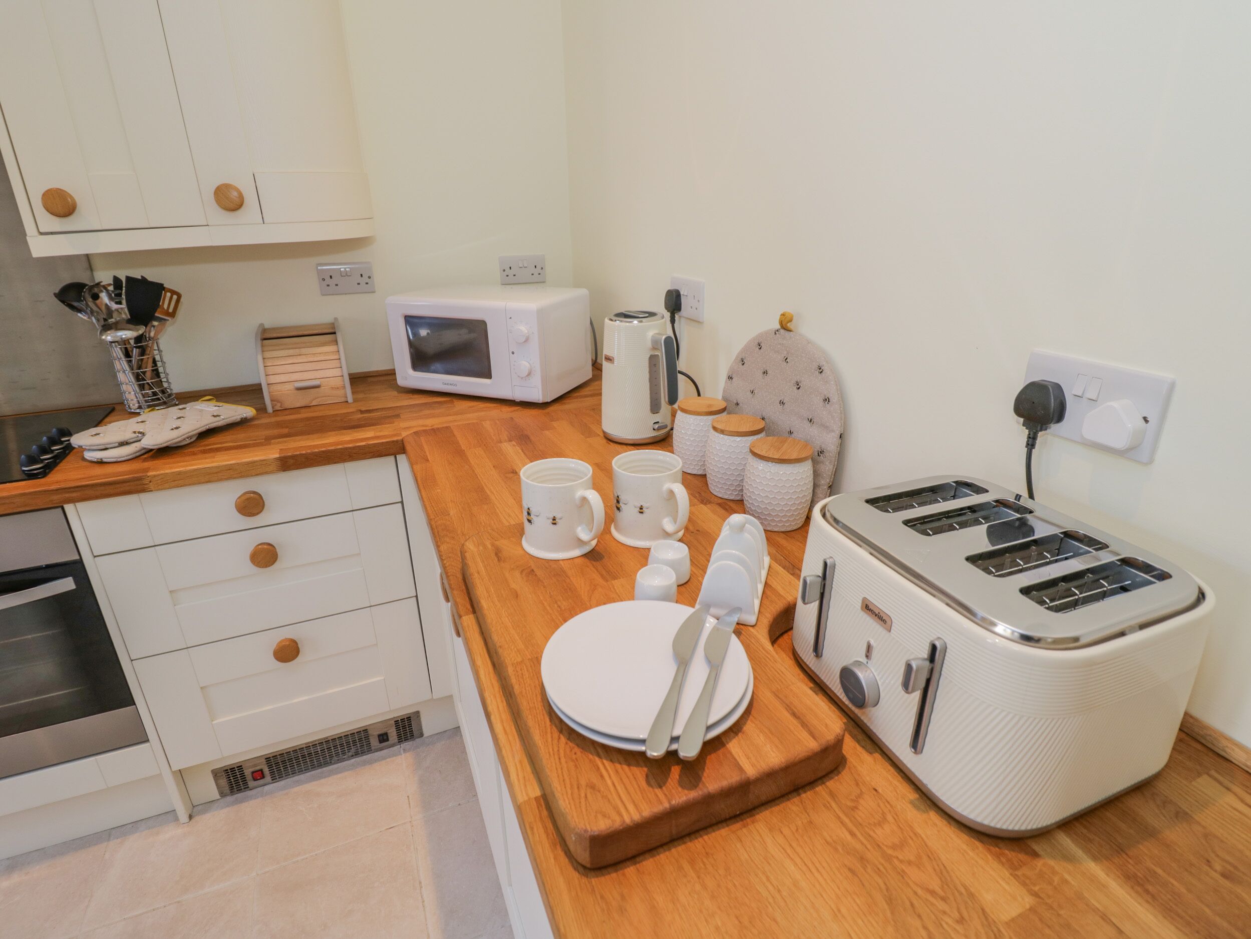 A compact kitchenette with a microwave, toaster, and kettle.