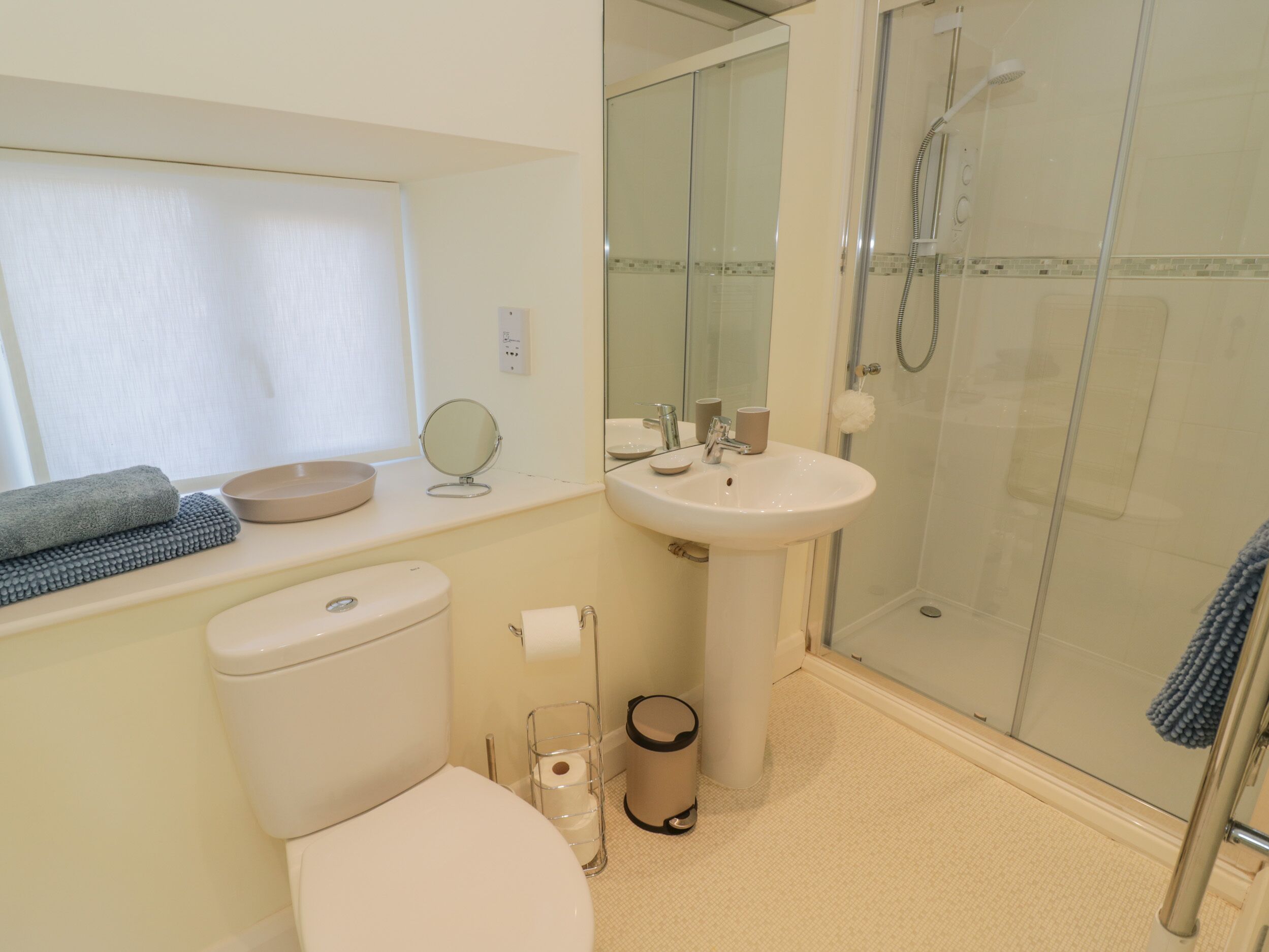 A bathroom with a toilet, sink, and shower.