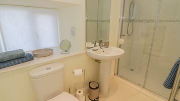 A bathroom with a toilet, sink, and shower.