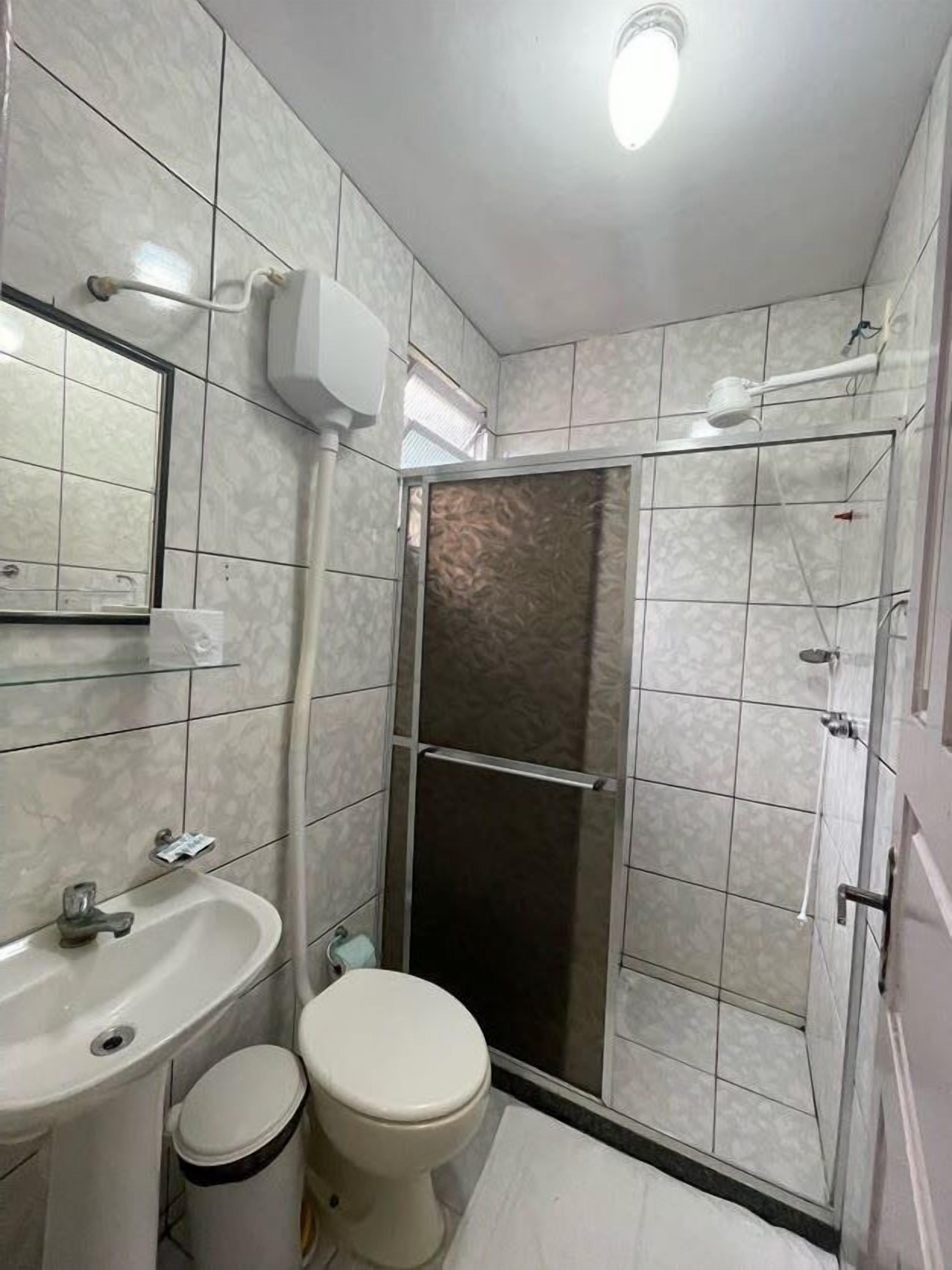 A bathroom with a shower, sink, and toilet.