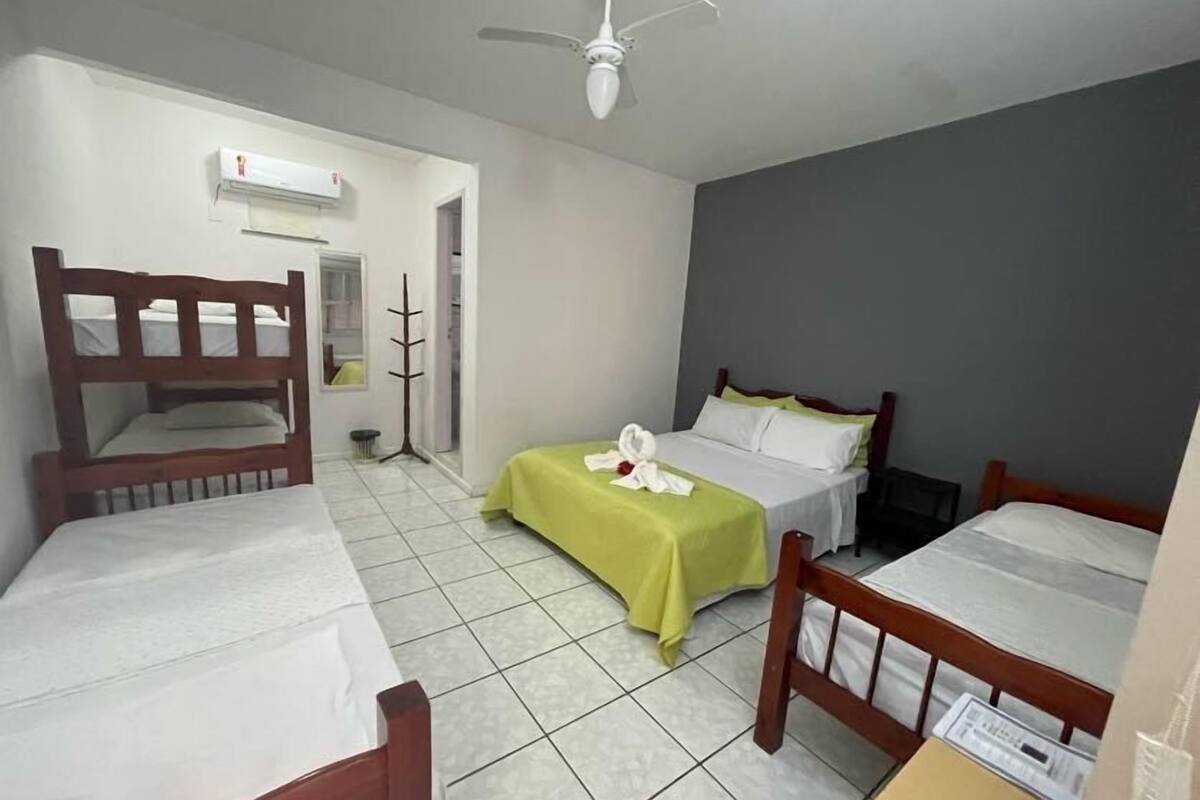 A hotel room with two single beds, a ceiling fan, and a window.