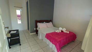 Ein ordentlich eingerichtetes Schlafzimmer mit Bett, einem kleinen Tisch und einem Fenster.