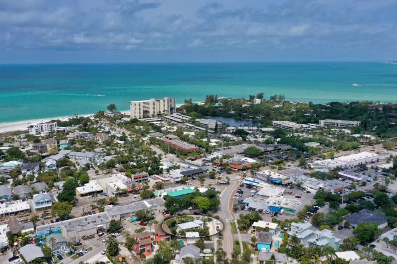An aerial view of a coastal town with buildings, roads, and a beach.