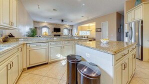 A spacious kitchen with granite countertops, white cabinetry, and stainless steel appliances.