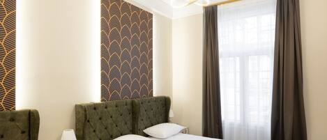Ein Hotelzimmer mit einem großen Bett, einem Nachttisch mit Lampe und einer Wand mit Muster.
