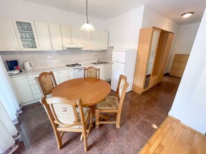 Cozy kitchen area with a round dining table and four chairs, featuring white cabinetry and an oven.
