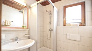 Une salle de bain avec une douche, un lavabo et des toilettes.