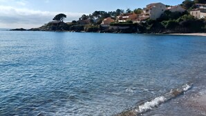 A coastal scene with clear blue water, a sandy beach, and buildings on a hillside. - Exceptional sea view villa with pool (Conca)