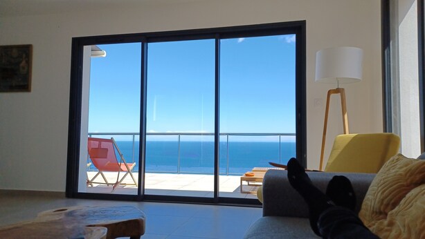 A room with a large sliding glass door leading to a balcony with a view of the ocean. - Exceptional sea view villa with pool (Conca)