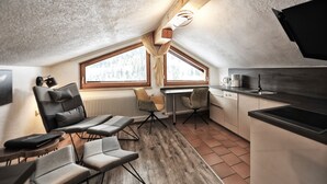 A compact kitchen with a dining area, large windows, and a modern design. - EULE by Summit Residence (Serfaus)