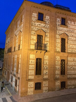 Un bâtiment historique doté de nombreuses fenêtres et de balcons, dont la façade présente un mélange de pierres et de briques.
