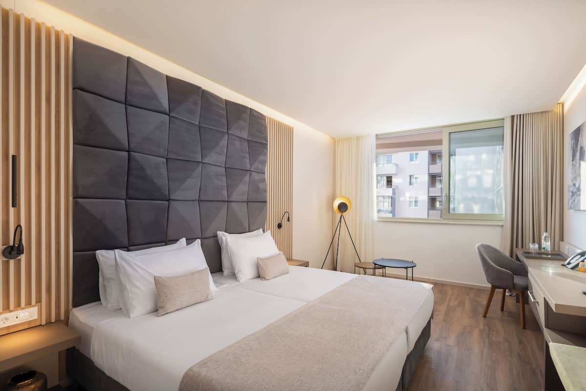 Een moderne hotelkamer met een groot bed, een bureau en een stoel.