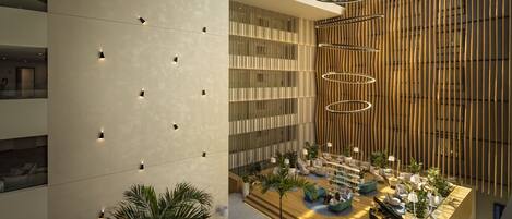 A spacious atrium with a modern design, featuring a central seating area with sofas and a piano, surrounded by plants and a wooden slatted wall.