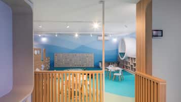 Children can play and dine in a safe, child-friendly space with a playpen, tables, and a climbing feature.