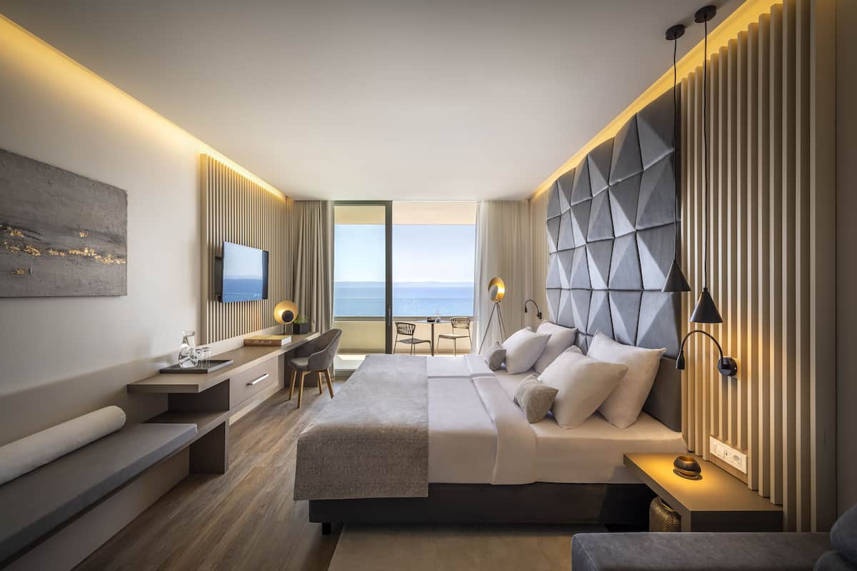 Een moderne hotelkamer met een groot bed, een bureau en een televisie.