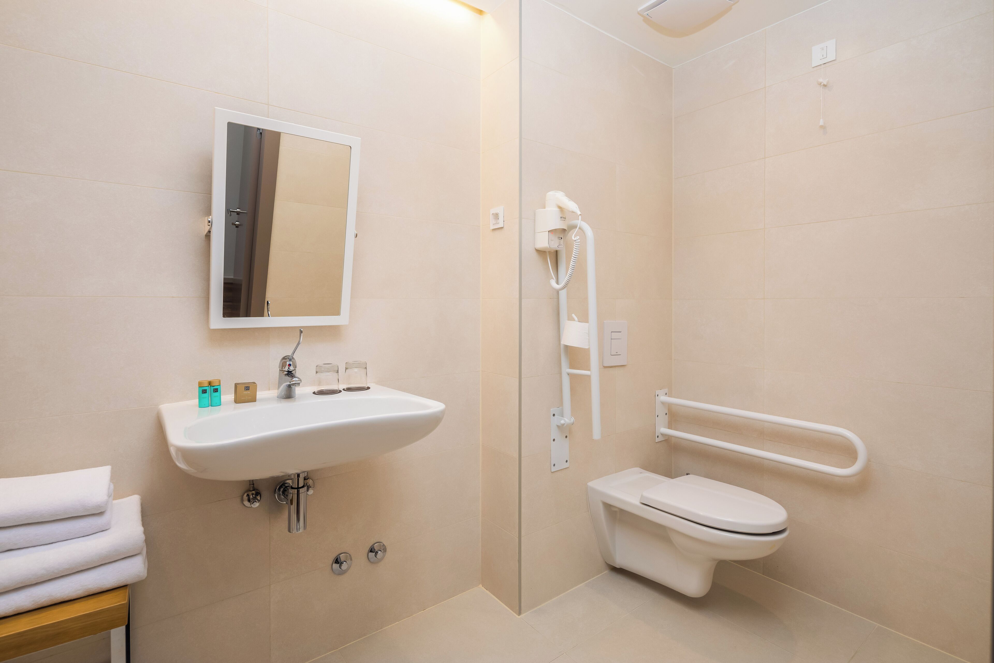 A modern bathroom with a sink, mirror, toilet, and shower.
