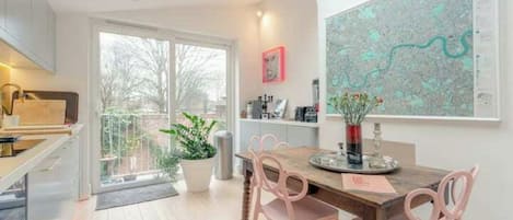 A modern kitchen with a dining area, a large window, and a map on the wall.