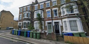 A row of terraced houses with a street in front. - Stylish & vast 2 bedroom apt in authentic London (London)