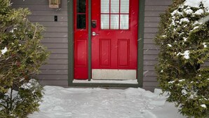 A red door with a number plate, a mailbox, and a small tree to the left. - Jay Peak's Premier Ski-In / Ski-Out Location-just steps from the trail (Jay)
