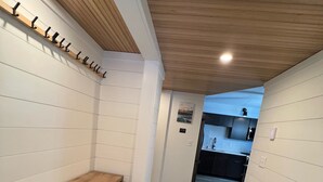 A hallway with a wooden bench, a coat rack, and a patterned rug. - Jay Peak's Premier Ski-In / Ski-Out Location-just steps from the trail (Jay)