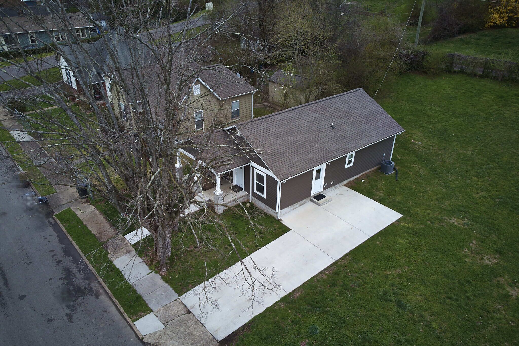 A two-story house with a front yard and a driveway.