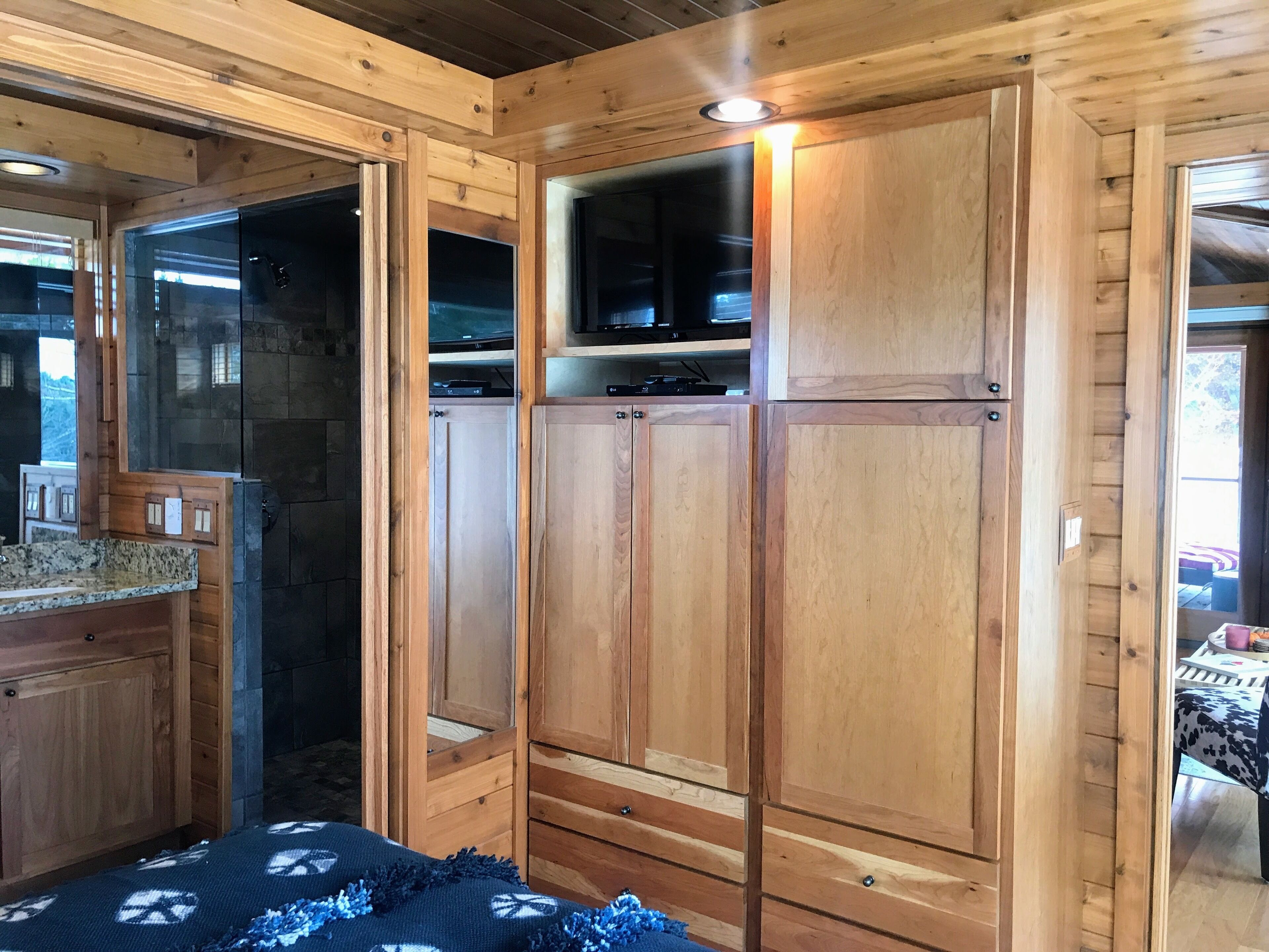 Ein Holzhütten-Interieur mit Küchenbereich, Einbauküche und einem gemütlichen Bett.
