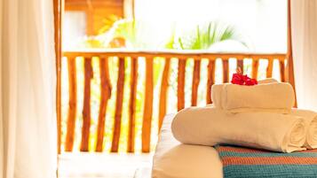 Relax on the balcony with lush greenery and enjoy the view from the large bed.