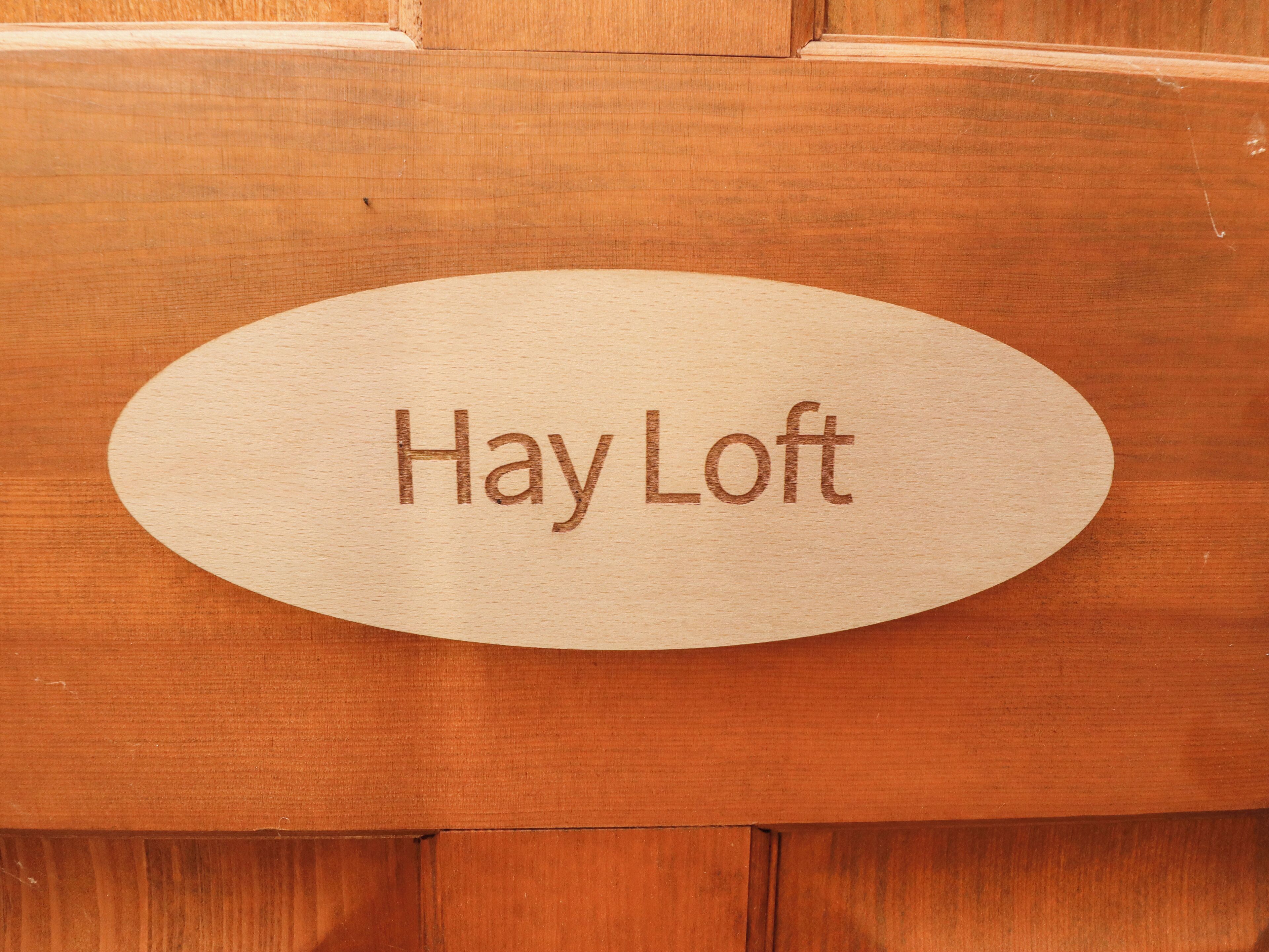 Ein Holzbrettchen mit der eingravierten Aufschrift "Hay Loft".