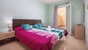 Een slaapkamer met een bed, nachtkastje en een kast.