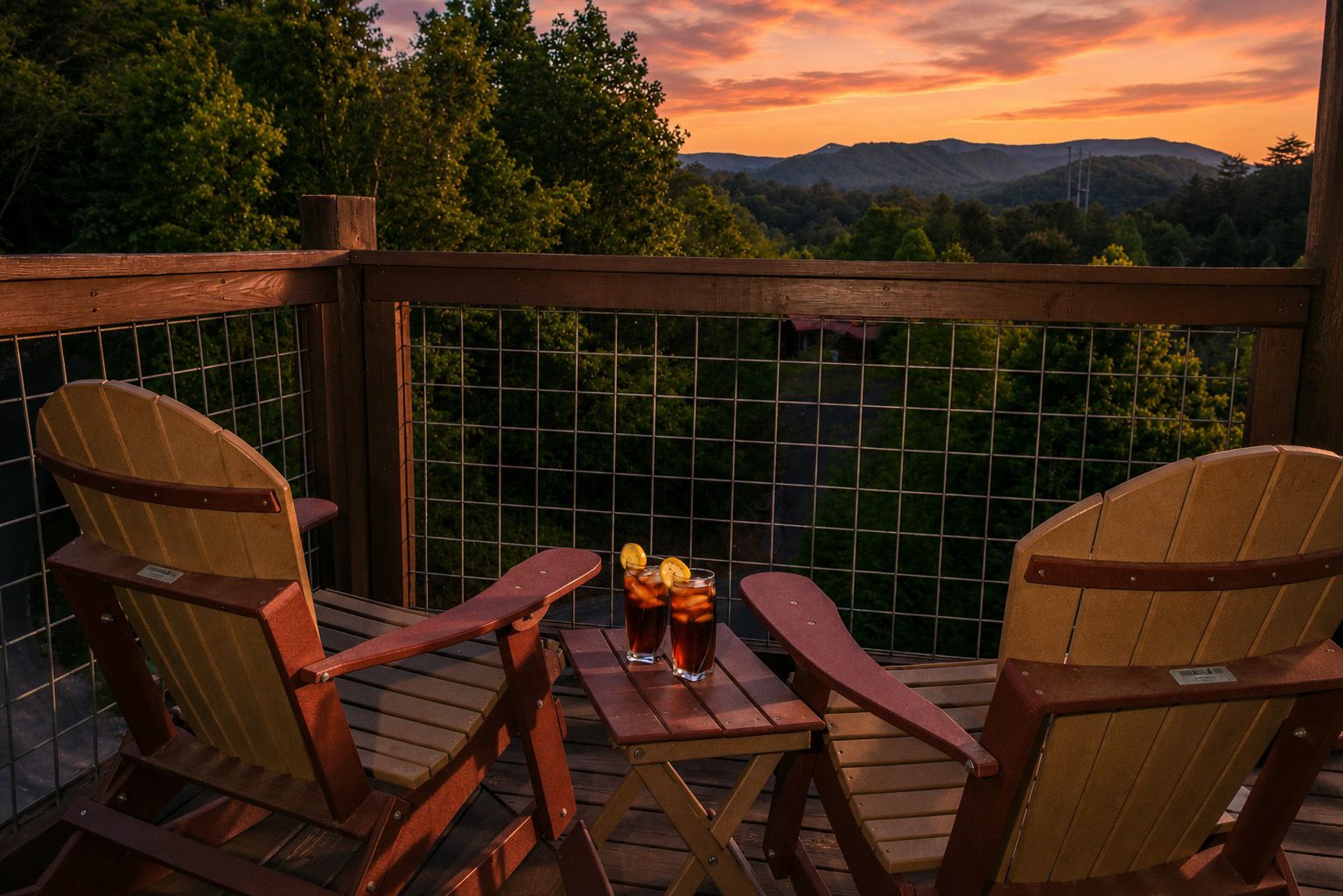 Terraza de madera con dos sillas Adirondack y una mesa, con vistas a un paisaje montañoso.