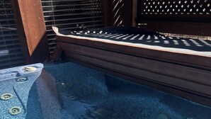Una vasca idromassaggio con superficie blu strutturata e un rivestimento in legno tutt'intorno.