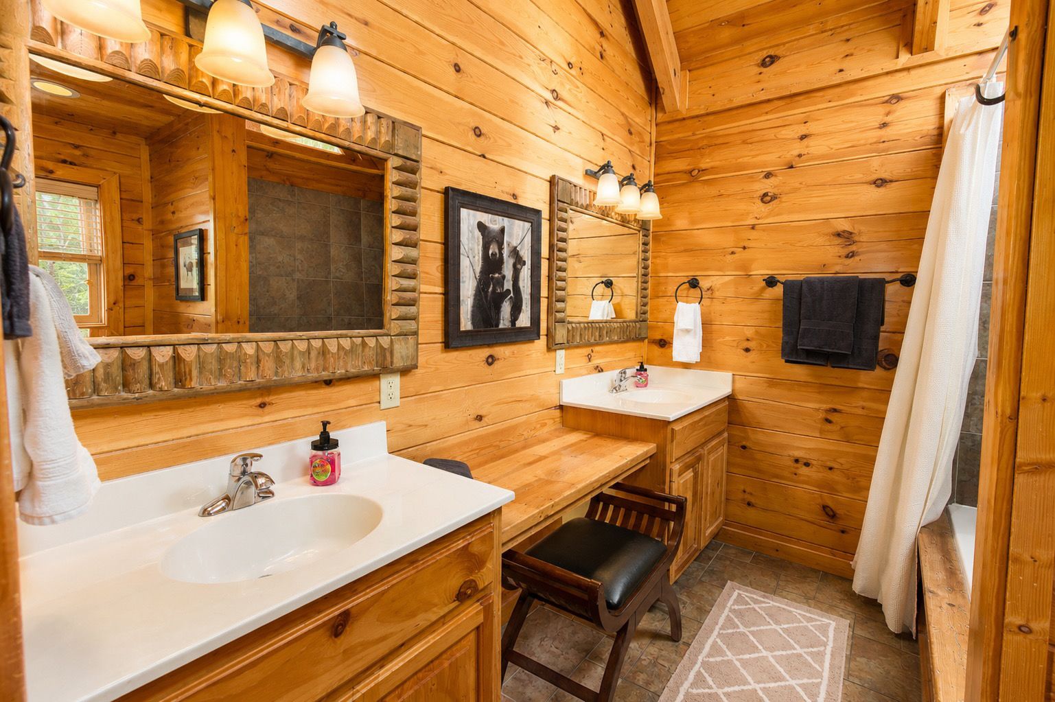A wooden cabin bathroom with a sink, mirror, and a chair.