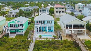 A coastal residential area with houses featuring balconies and a central swimming pool. - Just Beachy: Stunning 4BR Oceanfront Home + Private Pool (St. Augustine)