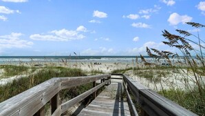 A wooden boardwalk leading to a beach with sand dunes and grasses. - Just Beachy: Stunning 4BR Oceanfront Home + Private Pool (St. Augustine)