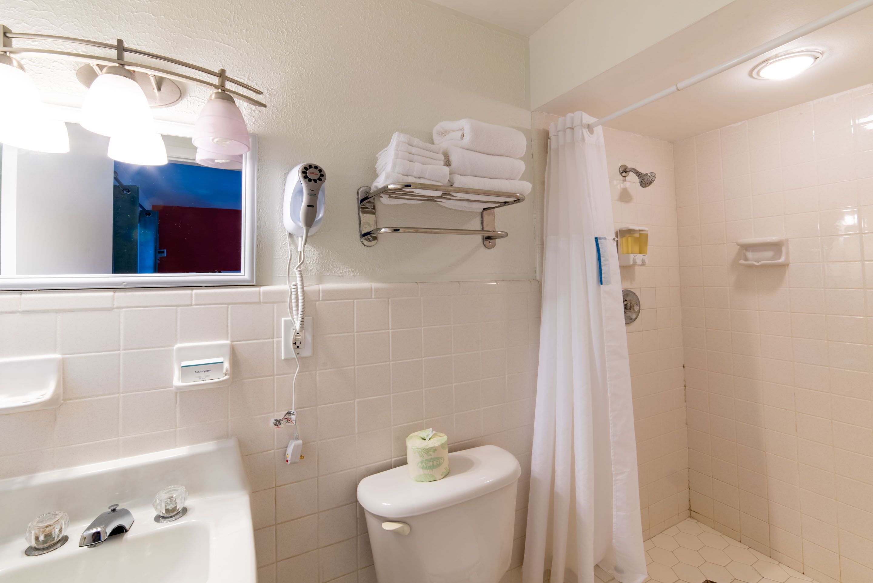 A bathroom with a bathtub, toilet, and shower curtain.