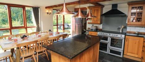 A kitchen with wooden cabinets, a central island, and a large stove.
