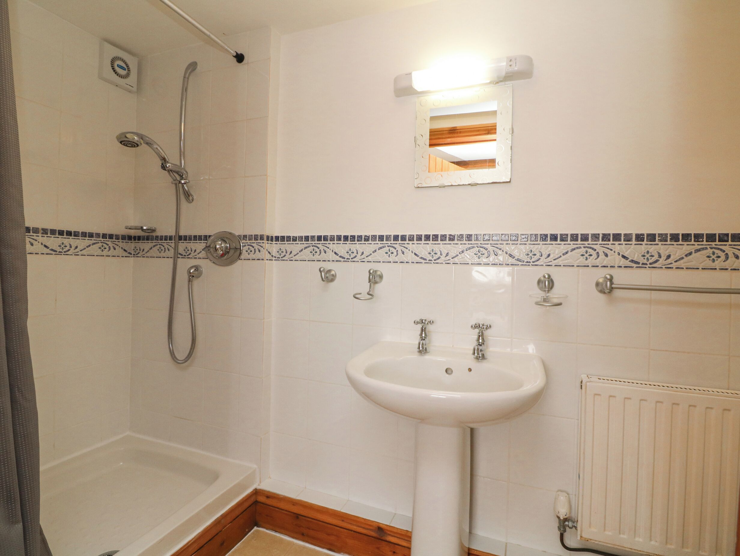 A bathroom with a shower, a sink, and a toilet.