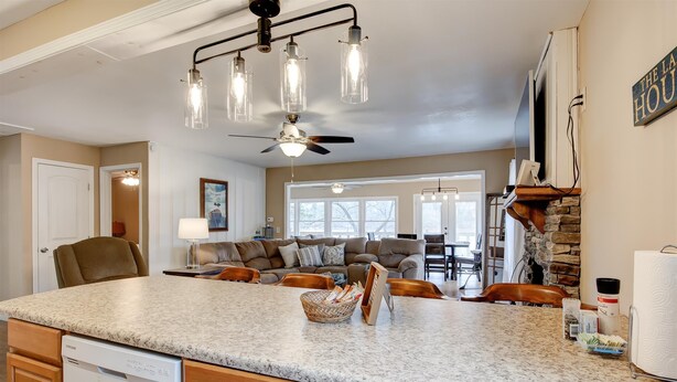 A spacious kitchen with a granite countertop, a dishwasher, and a ceiling fan. - Spacious Lake House Retreat! (Westminster)
