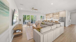 A modern living room with a sofa, a dining table, and a kitchen area with cabinets and appliances. - Steps to Beach/Siesta Village-Resort Pool w/Slide (Siesta Key)